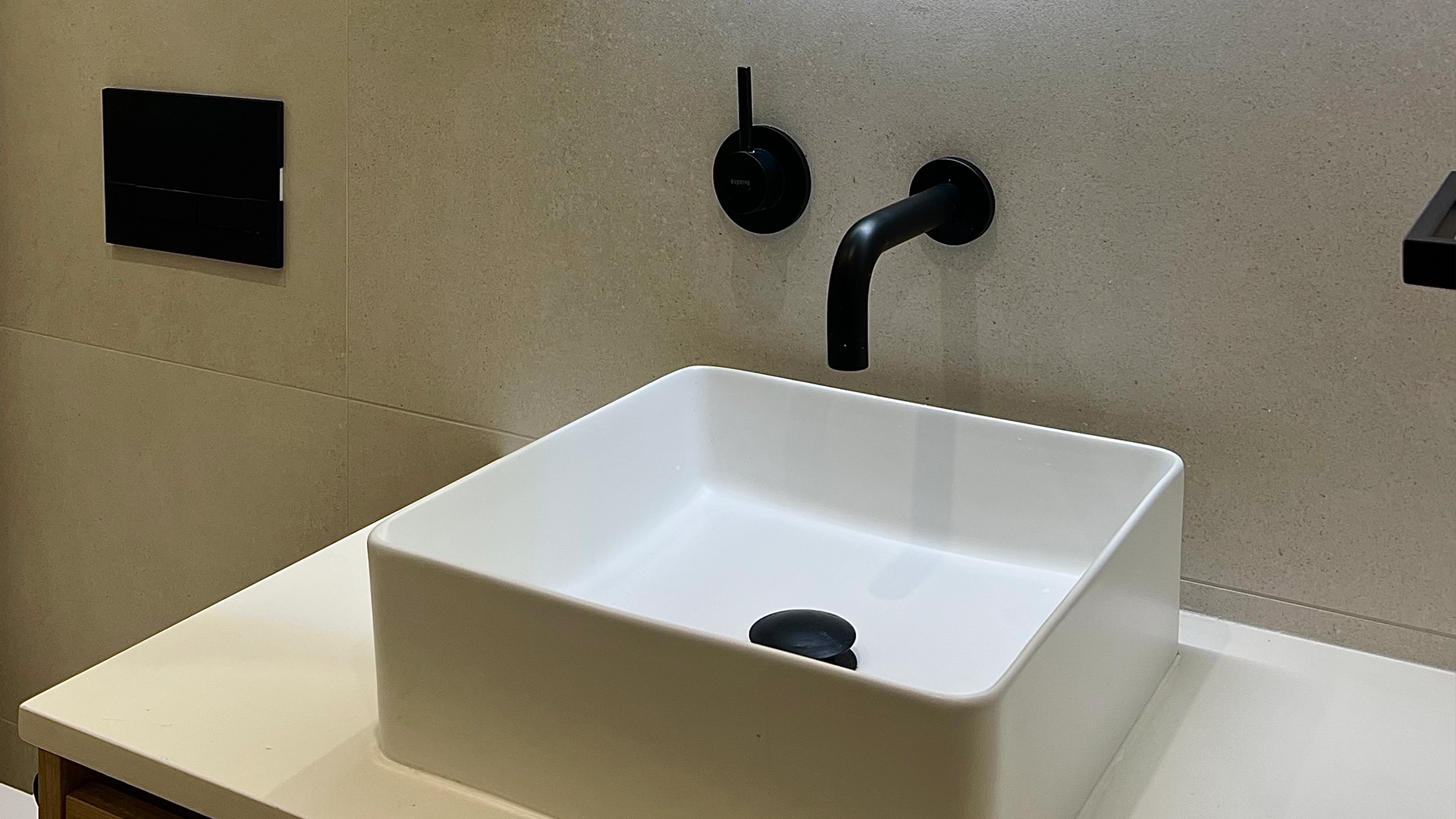 Reforma integral del baño de un piso de Barcelona con grifería empotrada y lavabo de sobremesa.