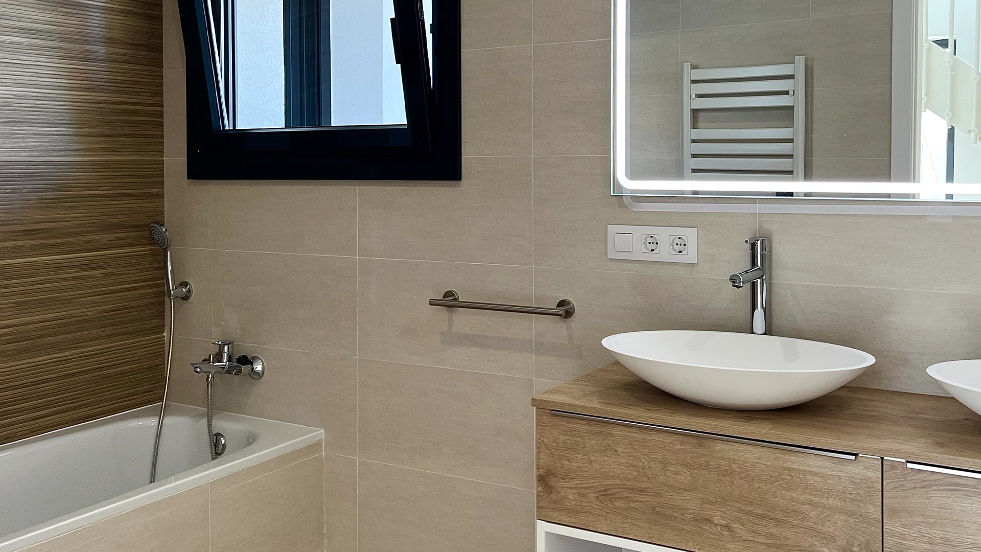 Baño reformado con gres porcelánico en tonos cálidos y toques de madera