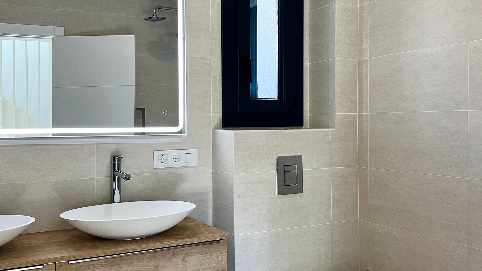 Baño reformado con gres porcelánico e inodoro empotrado