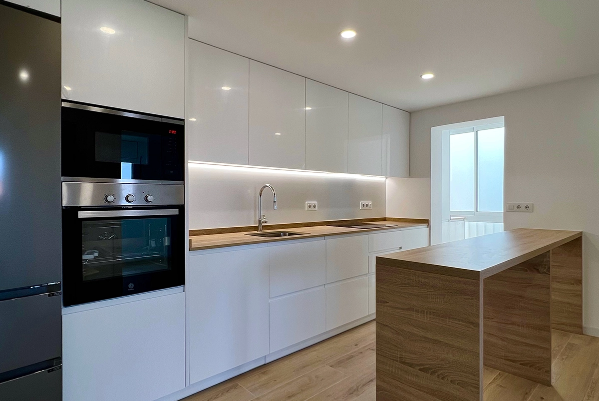 Reforma de cocina en un piso en Sant Boi con península en madera.