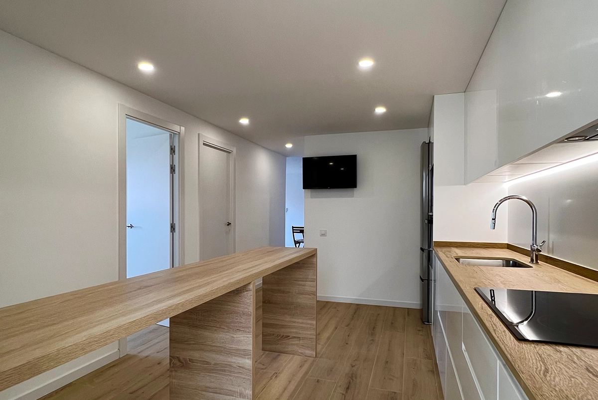 Vista de la encimera y la barra americana de la cocina de un piso en Sant Boi